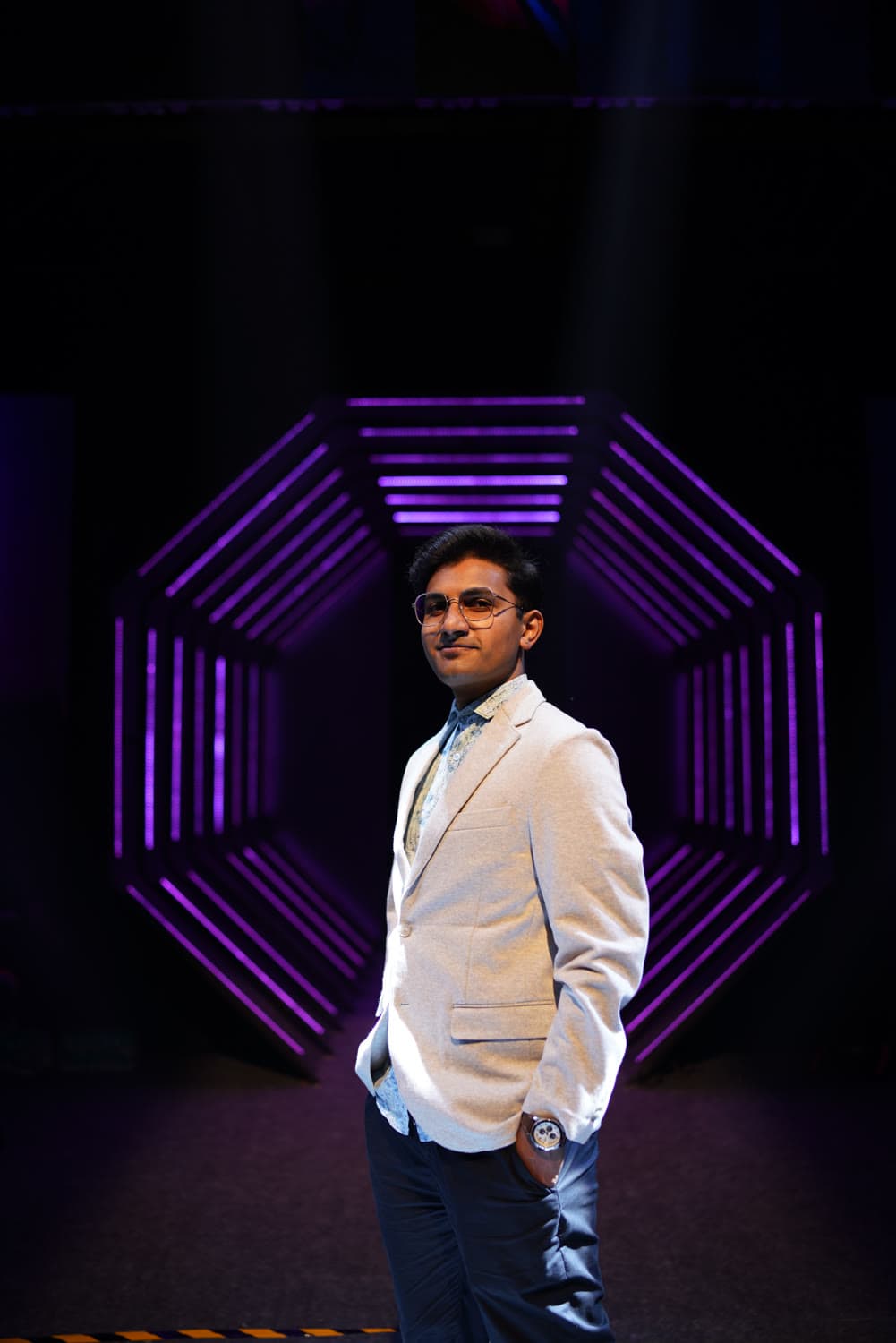 Standing in front of the magenta hexagonal stage light array