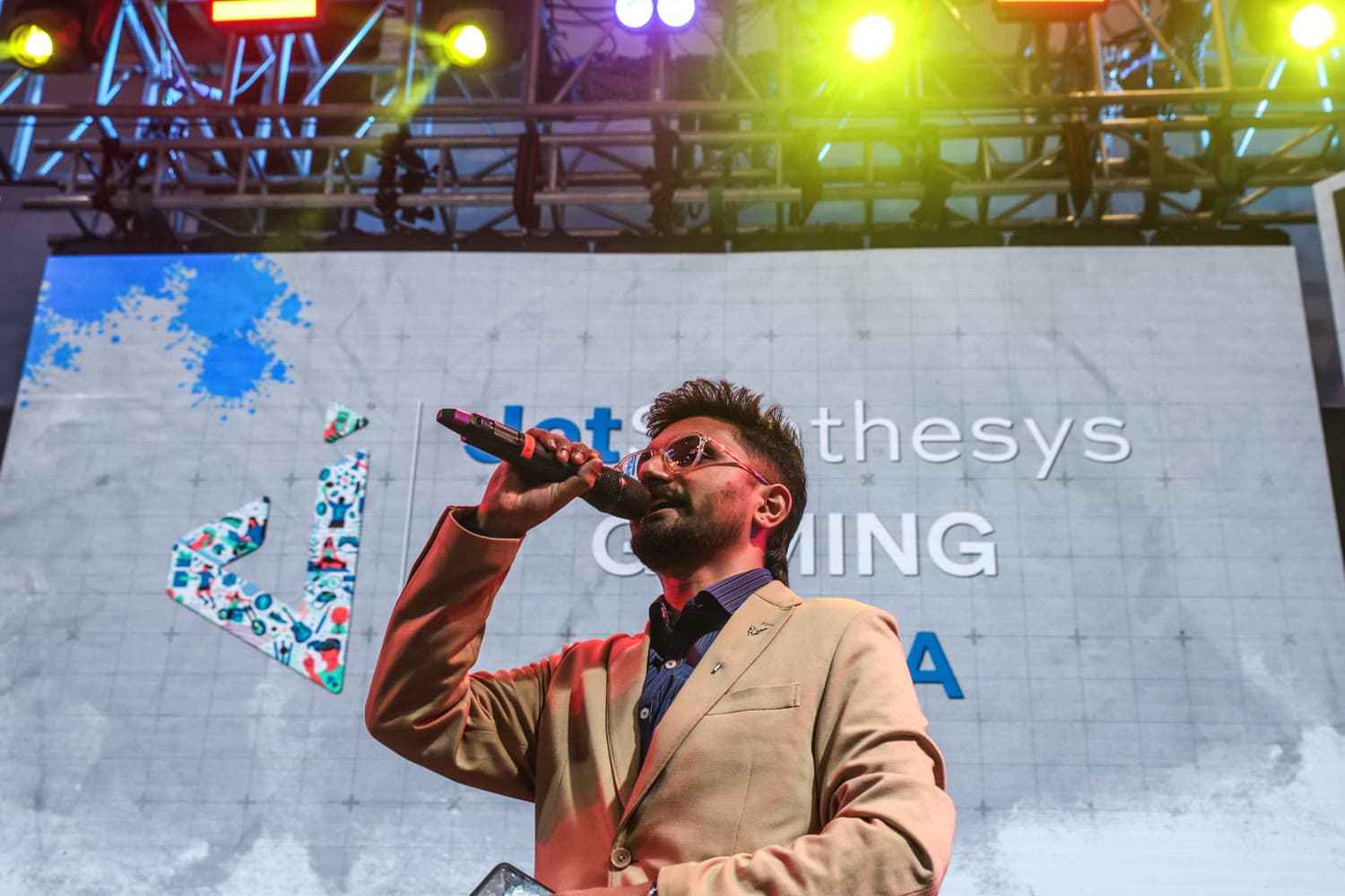lucif3r on the JetSynthesys Gaming Arena stage, mic in hand, gold blazer